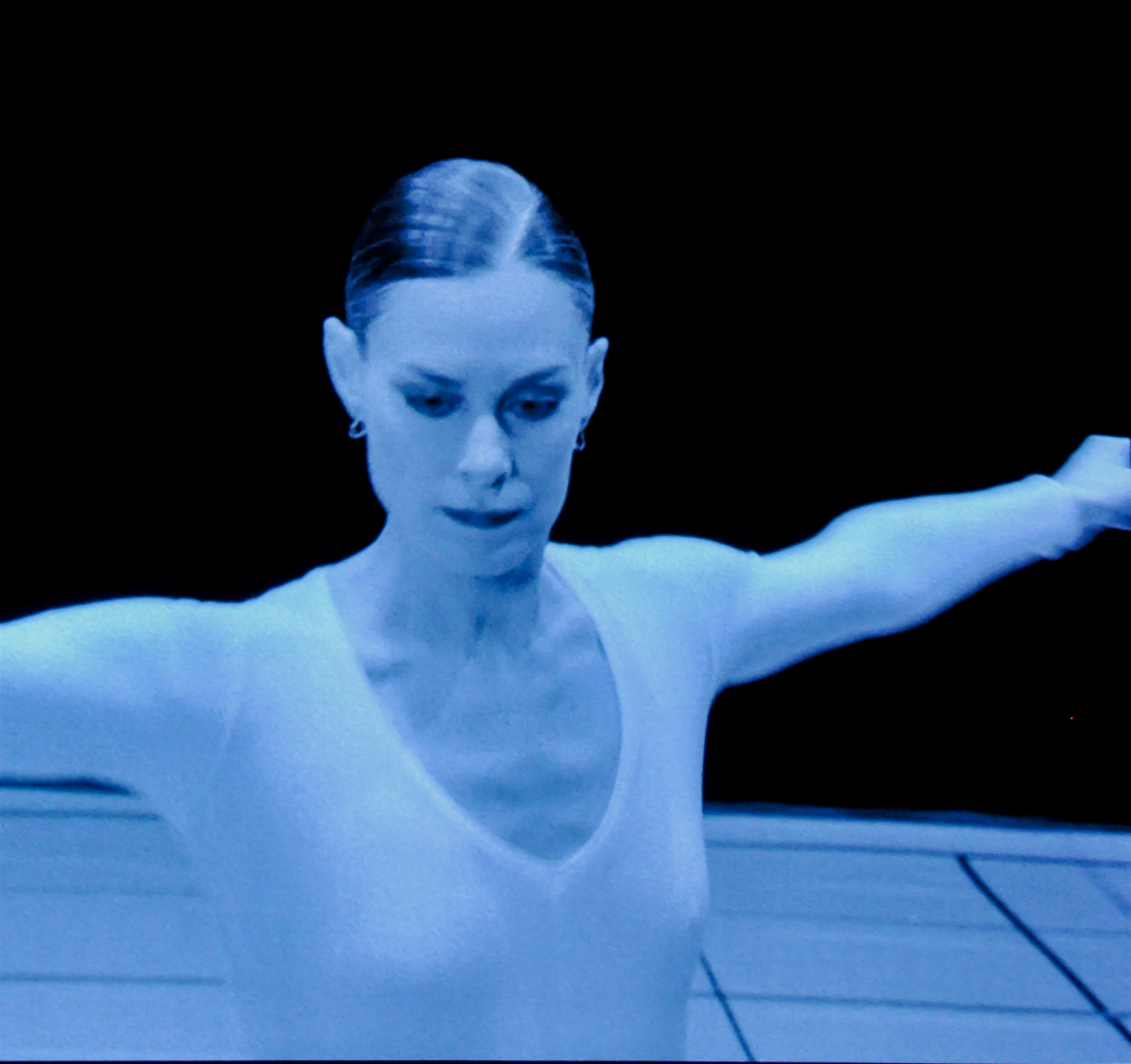 A film still of Lucinda Childs. Her arms are outstretched.